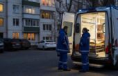 Бастрыкин взял на контроль расследование нападения на бригаду скорой в Красном Селе Автомобиль скорой помощи у жилого дома, рядом стоят двое сотрудников бригады. Иллюстрация к новости о безопасности работников скорой помощи.
